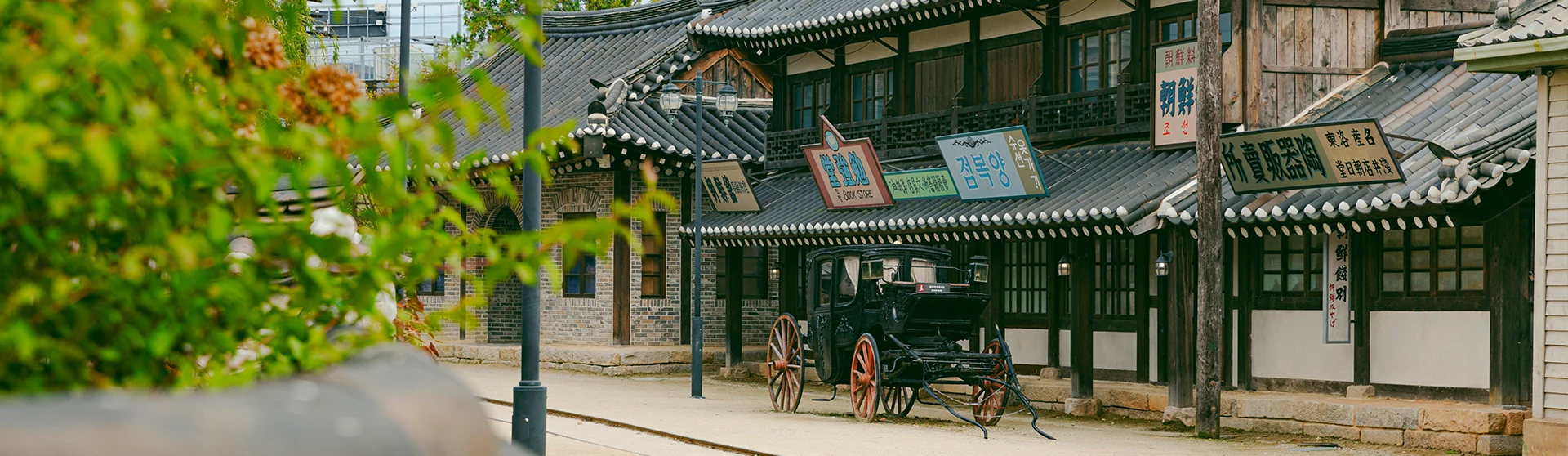 개화기 풍경을 재현한 한옥 상점 거리에 검은 마차가 처마 아래 서 있는 선샤인 스튜디오 모습