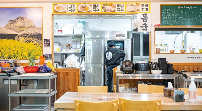 고기국수 멸치국수 비빔국수 메뉴판이 걸린 국수 식당의 주방과 내부 모습