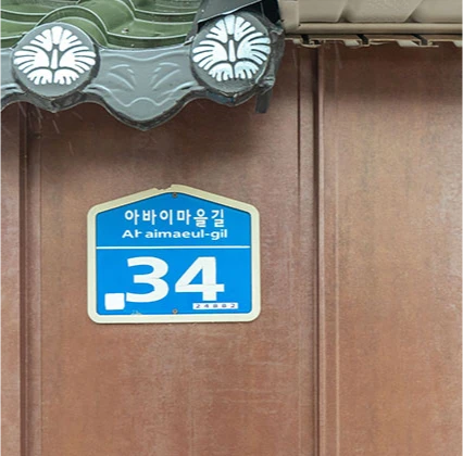 기와 처마 아래 아바이마을길 34 번지가 적힌 파란 도로명 주소판