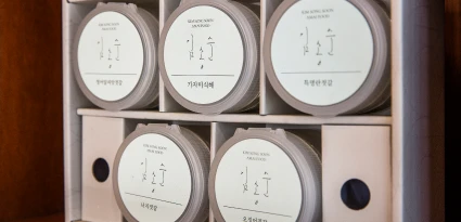 김송순 로고가 붙은 둥근 용기들이 가자미식해와 명태회젓 등 종류별로 가지런히 진열된 모습
