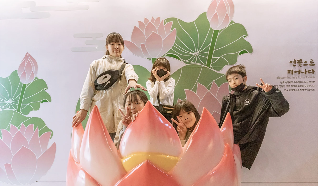 커다란 분홍 연꽃 포토존 앞에 참가자들이 모여 환하게 웃으며 기념사진을 찍는 모습