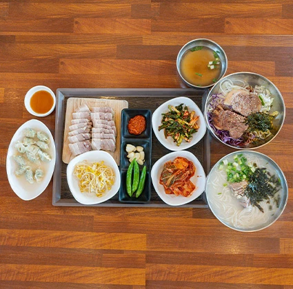수육과 만두, 두 가지 국수와 여러 반찬이 가득 차려진 2인 세트 한 상