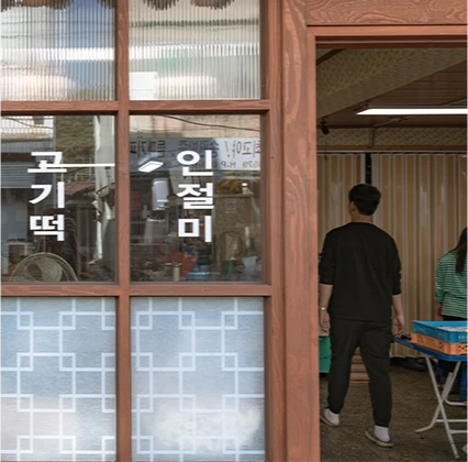 고기떡과 인절미라 적힌 유리문 너머로 직원이 오가는 고려떡집 입구