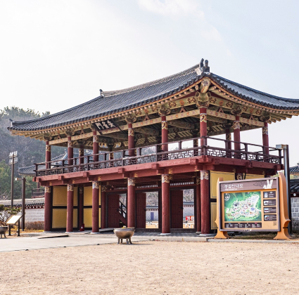 가야테마파크에 재현된 이층 누각 건물과 옆에 세워진 관람 안내도