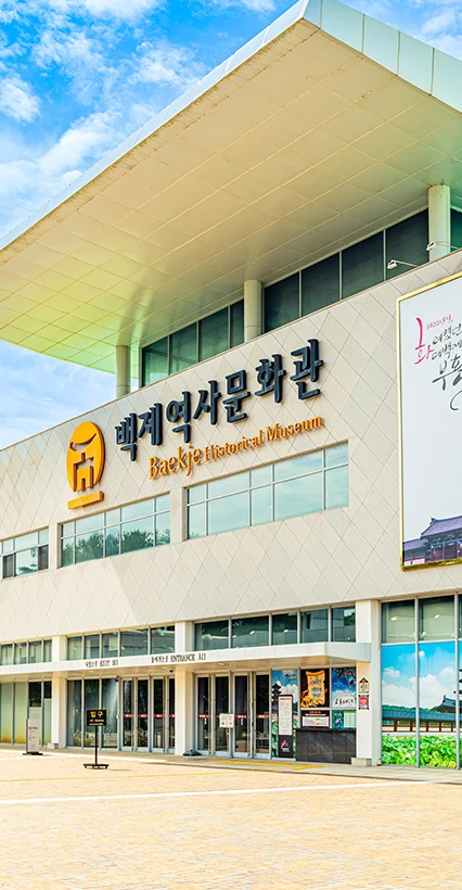 맑은 하늘 아래 백제역사문화관 현대식 건물의 외관과 입구를 올려다본 모습