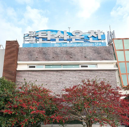 제주 산방산 탄산 스파 파란 간판이 걸린 건물 외관과 붉게 물든 나무들