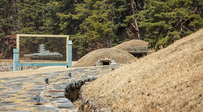 솔숲을 배경으로 백제 왕릉 봉분들이 늘어서고 능사 모형 안내판이 세워진 왕릉원 전경