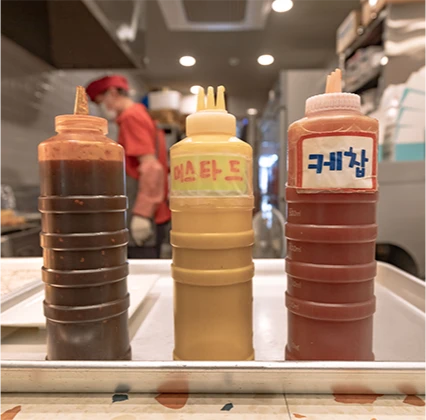 머스타드와 케찹 등 어묵에 곁들이는 소스통 세 개가 나란히 놓인 모습