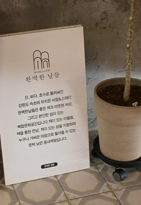 복합문화공간 동그란 책방을 소개하는 '완벽한 날들' 안내판과 옆에 놓인 키 큰 화분