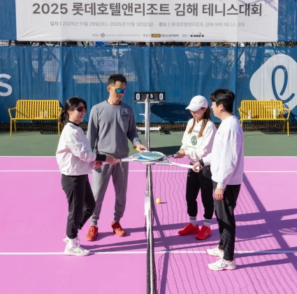 네 명의 선수가 네트 앞에 모여 라켓으로 순서를 정하며 경기를 준비하는 분홍 코트 장면