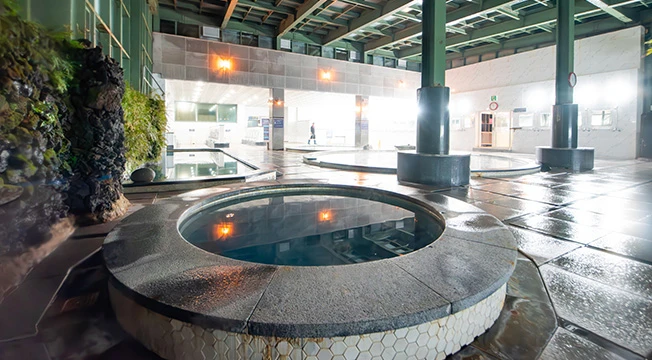 돌로 두른 둥근 욕탕과 젖은 바닥이 펼쳐진 산방산 탄산 실내온천 내부