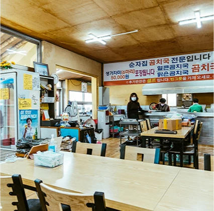 붉은 글씨의 곰치국 안내문이 걸린 천장 아래 손님들이 식사하는 순자집 곰치국 식당 내부