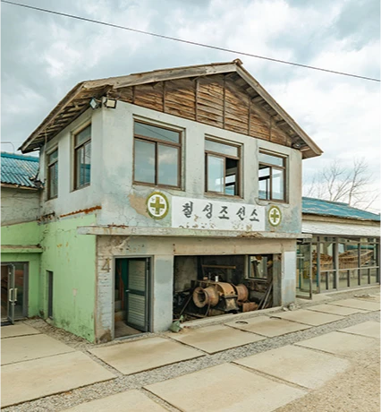 세월의 흔적이 묻어나는 칠성조선소 간판이 달린 낡은 이층 건물의 흐린 날 외관