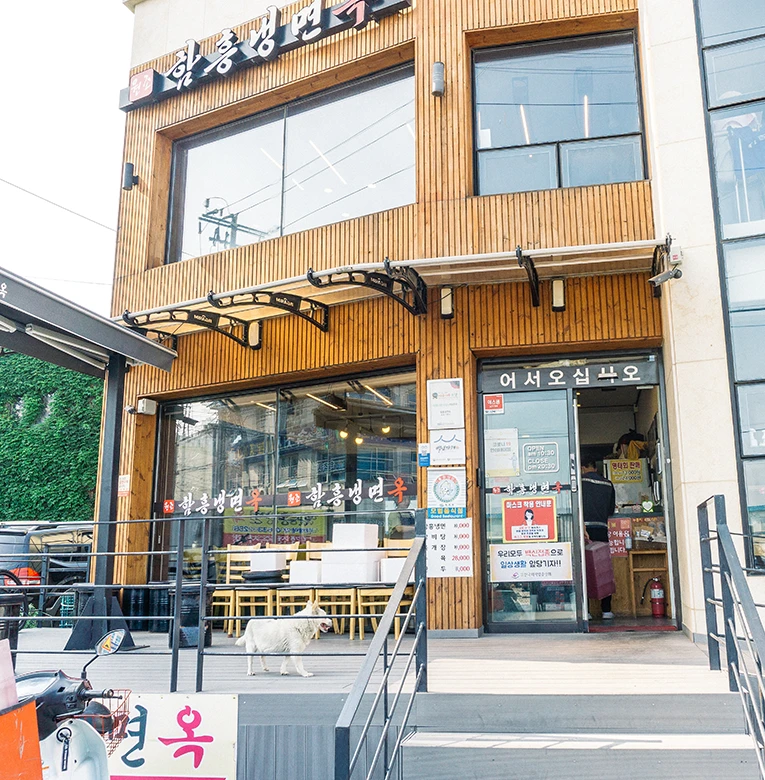 나무 차양이 드리운 함흥냉면옥의 정겨운 거리 외관