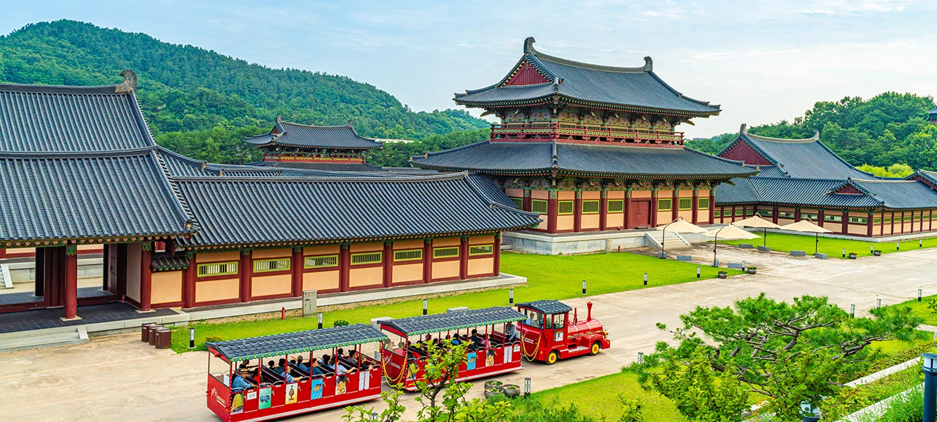 전각을 배경으로 관람객을 태운 빨간 사비로 열차가 마당을 도는 모습