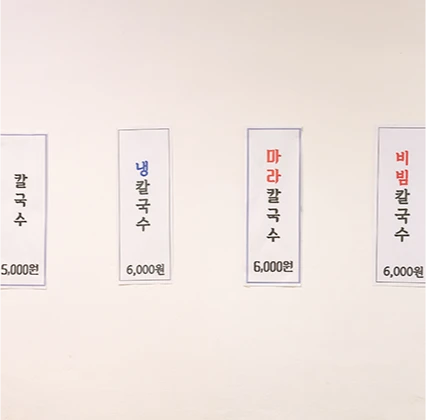 흰 벽에 칼국수와 냉칼국수, 마라칼국수 등 종류별 가격을 붙여 둔 가격표