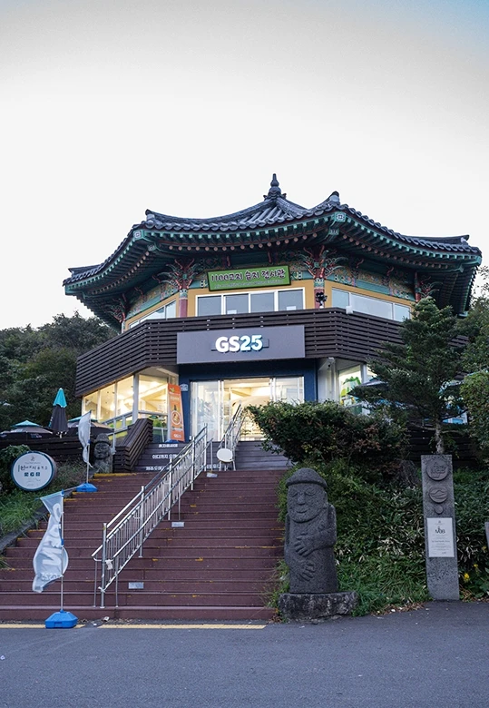 한옥 기와지붕을 얹은 1100고지 휴게소 건물 1층에 자리한 편의점, 계단 옆에 돌하르방이 서 있는 우리나라 최고지대 편의점
