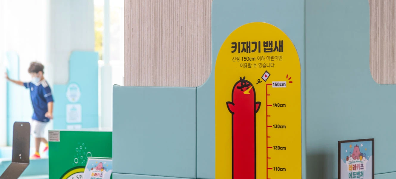 신장 150cm 이하 어린이만 이용할 수 있다는 안내가 적힌 노란 키 재기 조형물