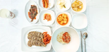 흰 접시에 담긴 아바이순대와 밥, 여러 밑반찬이 정갈하게 차려진 한 상