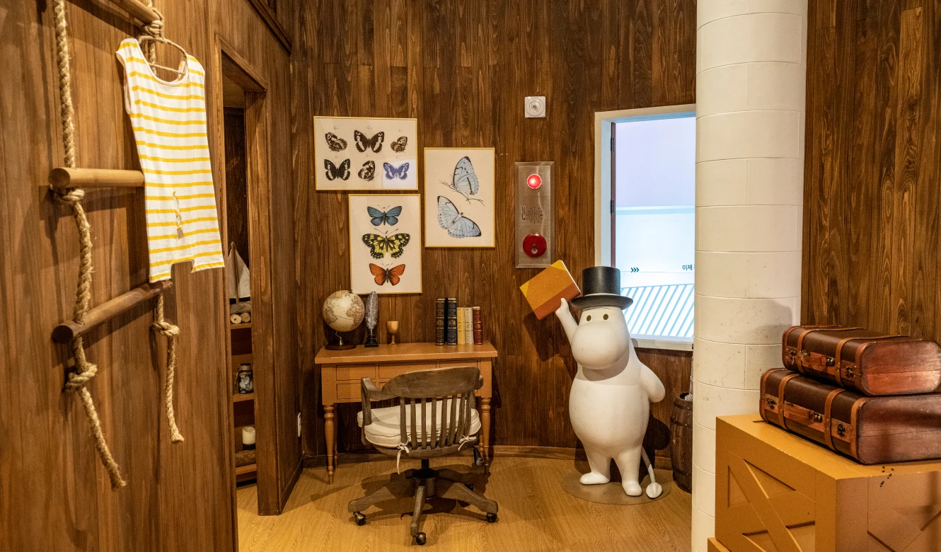 나비 표본과 책상, 지구본을 갖춘 무민파파의 원목 서재와 모자를 쓴 무민 조형물