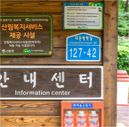 대관령 치유의 숲 안내센터 입구의 나무 간판과 대관령옛길 주소 표지판