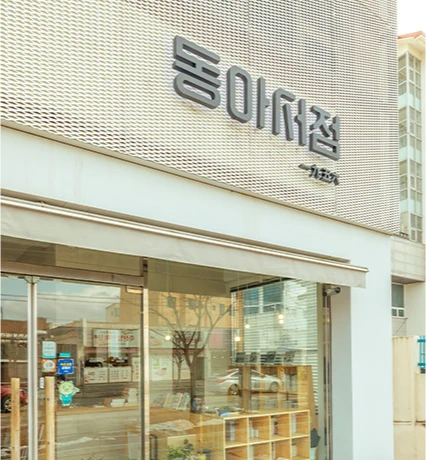 큼직한 한글 로고가 붙은 동아서점 입구, 유리문 너머로 책장이 들여다보이는 외관