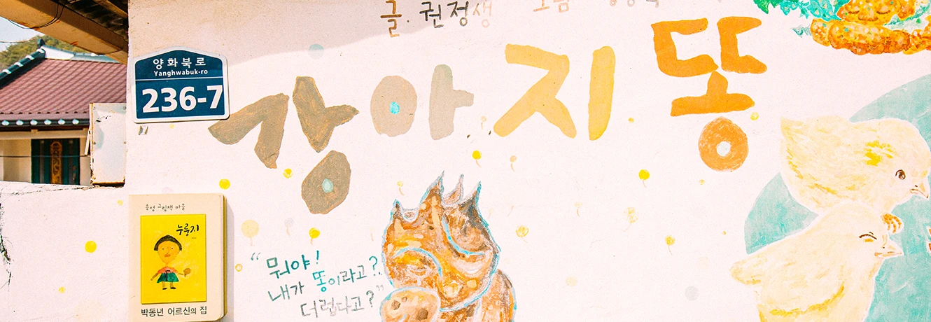 강아지똥 동화를 주제로 그린 노란빛 벽화, 별과 캐릭터가 어우러진 정겨운 담벼락