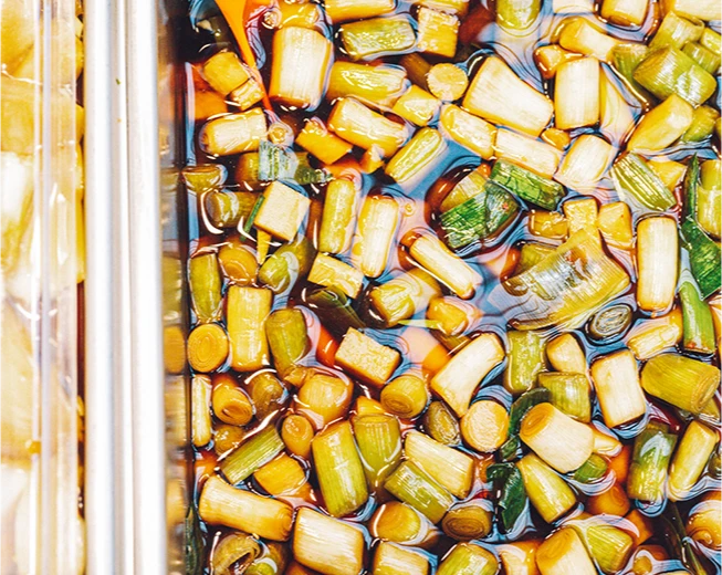 간장에 절인 마늘대 마농지가 통에 가득 담겨 있는 모습
