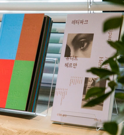 진열대에 세워 둔 책들 사이로 레티파크 표지가 보이는 아트숍 책 코너