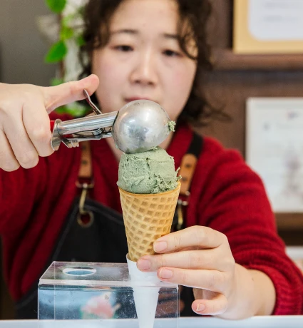 대표가 민트색 젤라또를 와플콘 위에 스쿱으로 올리며 정성껏 담아내는 모습