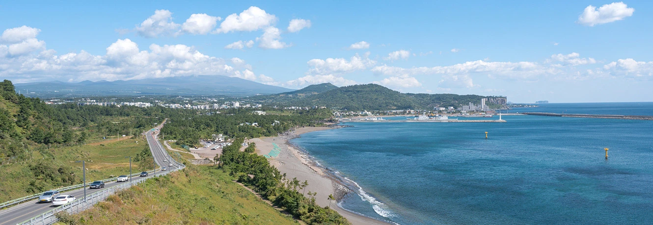 해안 도로와 백사장, 잔잔한 바다가 펼쳐진 산방연대에서 본 제주 남서쪽 풍경