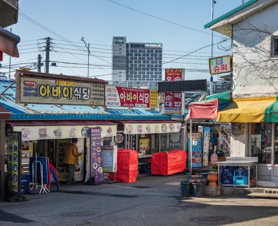 아바이식당 간판이 늘어선 속초 아바이마을 시장 골목과 오가는 사람들의 일상 풍경
