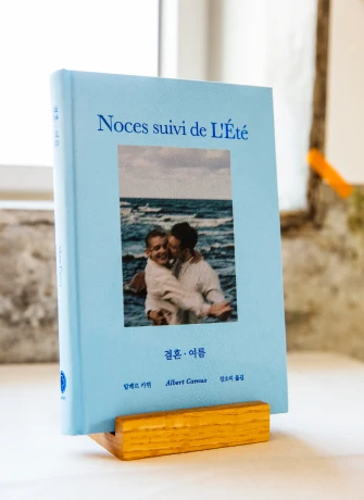 카뮈의 산문집 결혼 여름이 나무 받침대 위에 세워져 창가 햇살을 받고 있는 모습