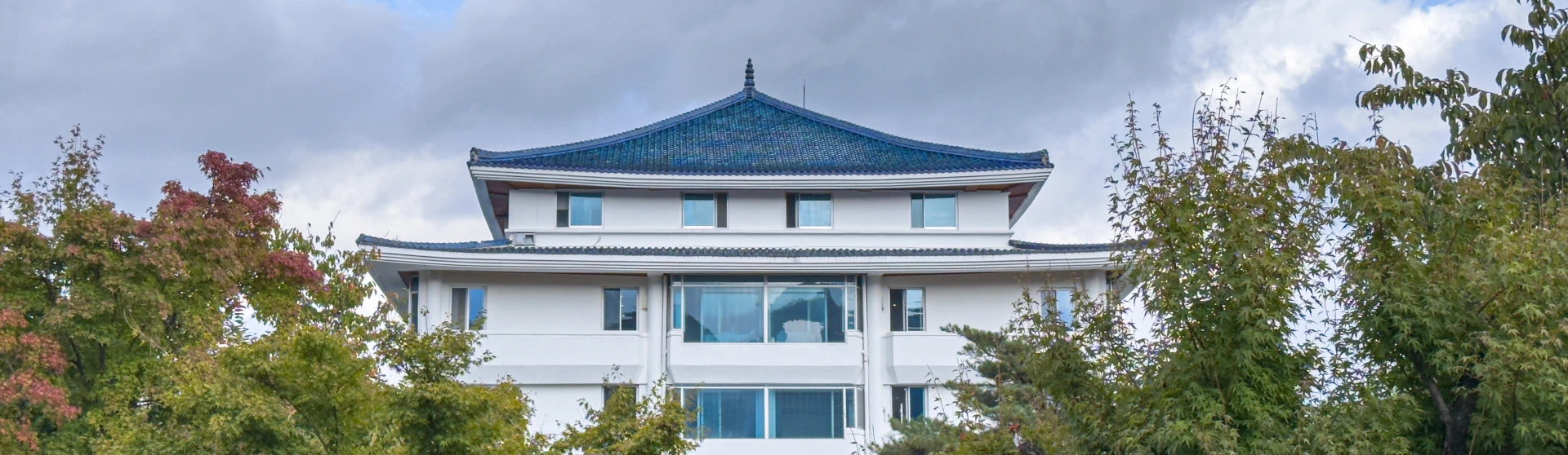 푸른 기와 지붕을 얹은 척산온천휴양촌 흰색 건물이 단풍 든 나무들 사이로 보이는 가을 풍경