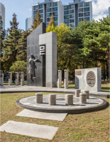 한글 자모를 형상화한 조형물과 인물 동상이 어우러진 한글문화공원의 기념물