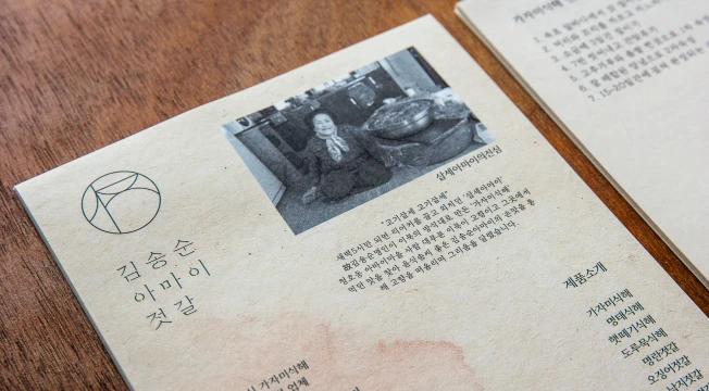 김송순아마이젓갈 로고가 새겨진 소책자에 명인의 흑백 사진과 제품 소개 글이 정갈하게 인쇄된 모습