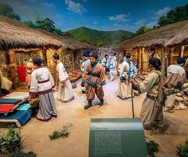 초가집과 한복 입은 인물 모형으로 백제 마을의 생활상을 재현한 박물관 디오라마