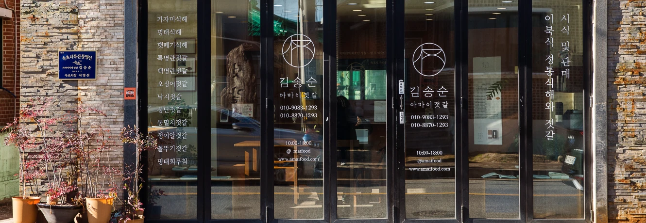 유리문과 간판을 갖춘 김송순아마이젓갈 매장의 깔끔한 외관